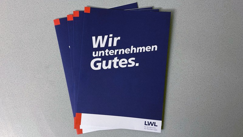 Ein Stapel mit Tagungsmappen des LWL mit der Aufschrift "Wir unternehmen Gutes."