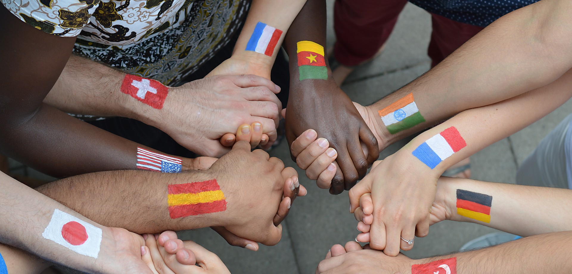 Foto von jungen Menschen verschiedener Nationalitäten, die sich an den Händen halten (Bild: AdobeStock / what4ever).