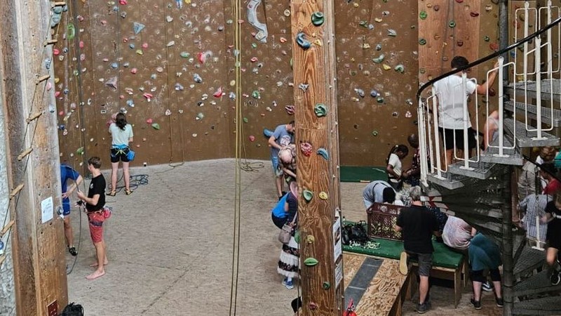 Eine Kletterhalle mit vielen Menschen.