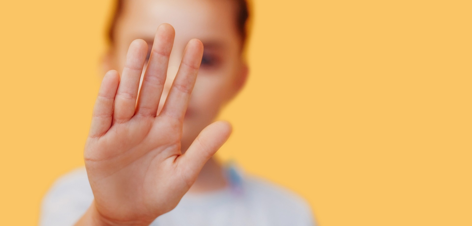 Kind hält eine Hand vor das Gesicht