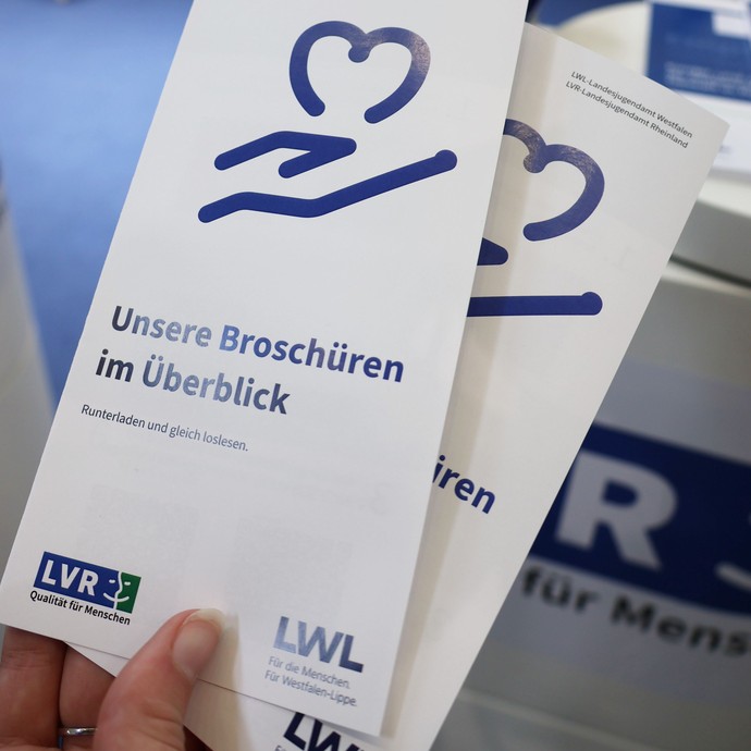 Eine Hand, die Infobroschüren von LWL und LWL hält. (vergrößerte Bildansicht wird geöffnet)
