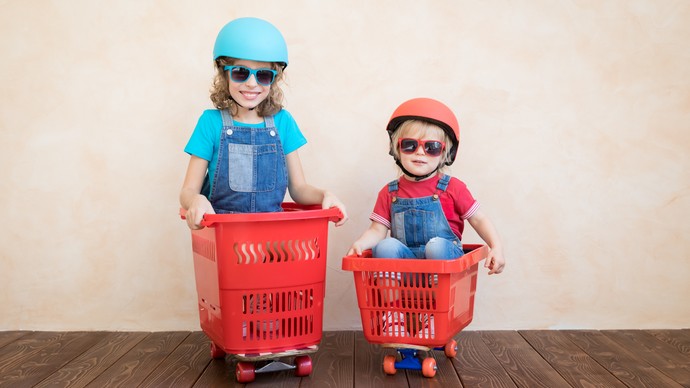 Zwei Kinder in Einkaufskörben (Bild: AdobeStock / DATEI-NR.: 259795839)