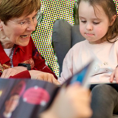 Eine Frau liest einem Mädchen ein Buch vor