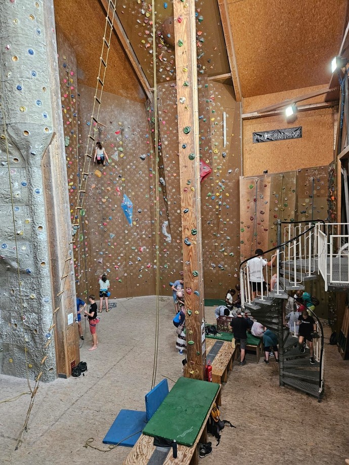 Eine Kletterhalle mit vielen Menschen.